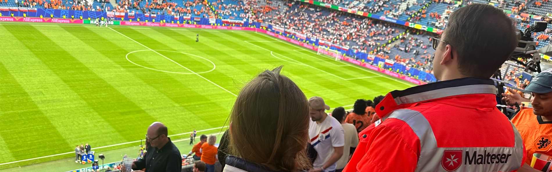 Zwei Menschen in Einsatzkleidung in einem Fußballstadion