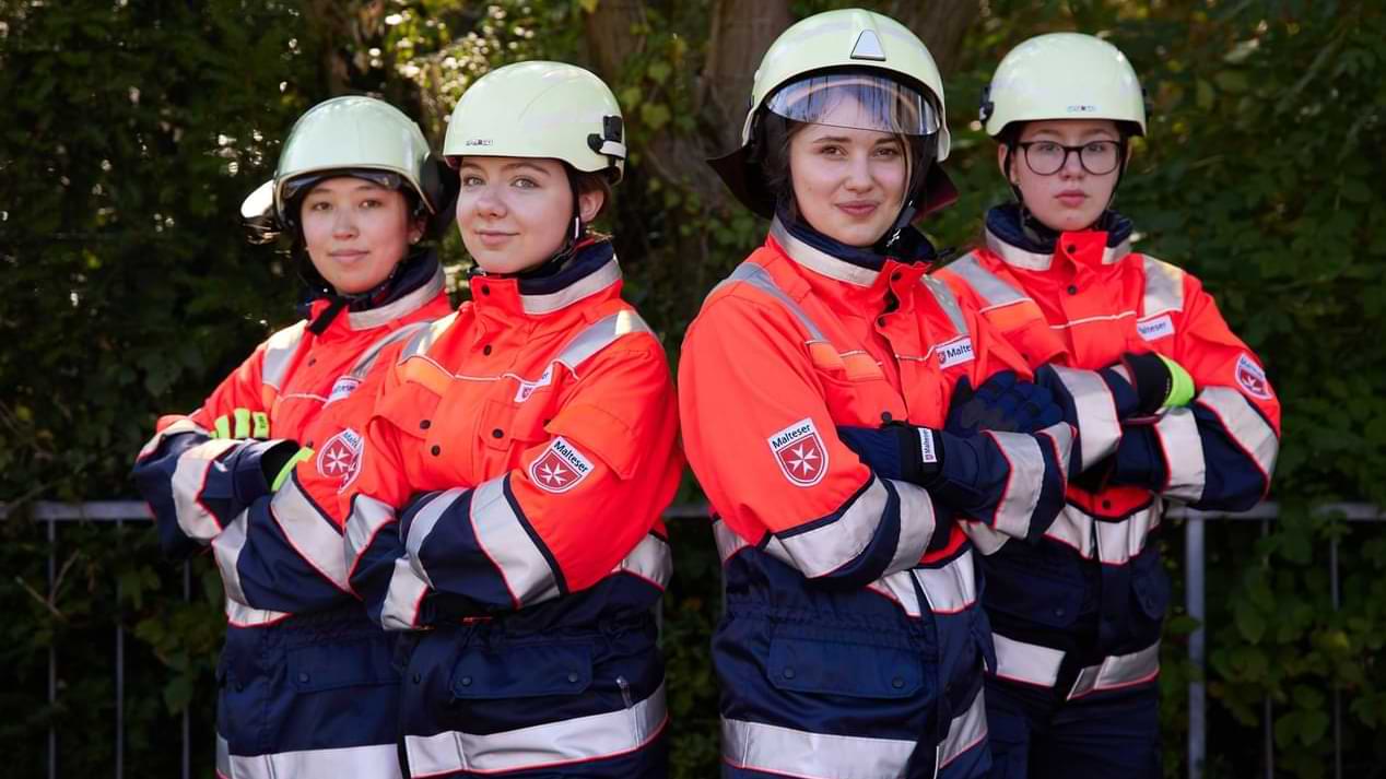 Vier junge Frauen in der Einsatzkleidung des Katastrophenschutzes.