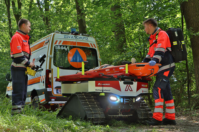 Zwei Personen und zwei Fahrzeuge im Gelände