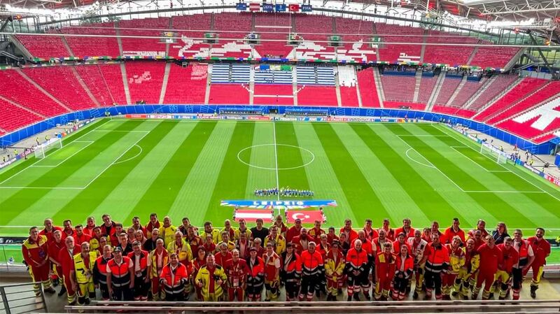 Ein Gruppenbild von Einsatzkräften mehrerer Hilfsorganisationen in einem Fußballstadion