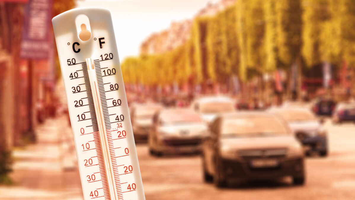 Thermometer im Vordergrund und Autos im Hintergrund.