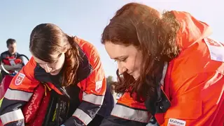 Zwei Frauen in Malteser Einsatzkleidung bei einem Sanitätseinsatz.