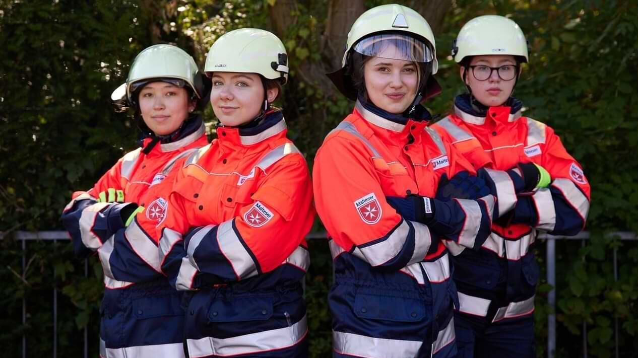 Vier junge Frauen in der Einsatzkleidung des Katastrophenschutzes.