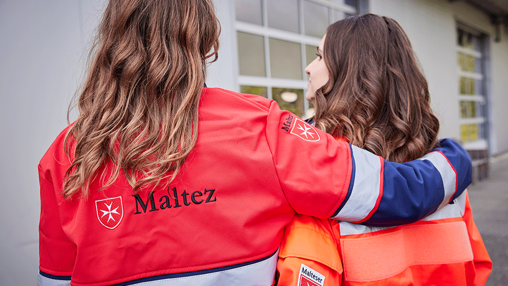 Zwei Frauen aus dem Malteser Volunteers-Programm umarmen sich. 