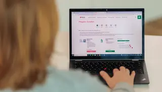 Eine Frau bestellt am Laptop die Malteser Pflegebox.