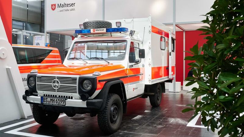 Eine zu einem Krankenwagen umgebaute Mercedes G-Klasse steht an einem Messestand